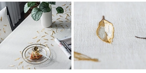 Macro detail of waterproof linen texture tablecloth with elegant golden leaf embroidery