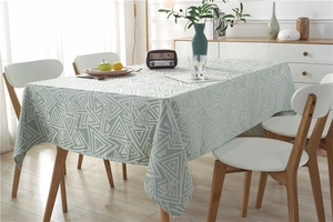 Close-up of modern geometric jacquard tablecloth with textured blue triangular patterns