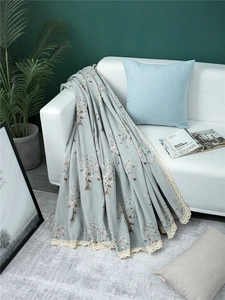 Close-up of chenille sofa cover with blue plant patterns and elegant lace borders