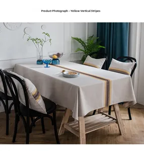 Detail of modern cotton linen table runner with yellow stripes and matching cushion set