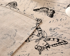 Close-up of linen tablecloth with vintage butterfly print and fine stitching details