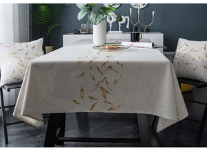 Detailed texture of waterproof linen tablecloth with golden leaf embroidery and matching cushions