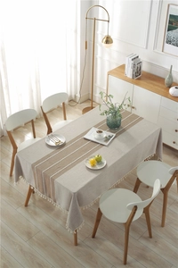 Close-up of jacquard embroidery linen tablecloth featuring beige tassels and lace detail