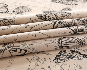 Close-up of vintage butterfly and script print on thick linen-textured tablecloth