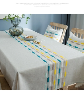 Detailed embroidery on linen tablecloth with colorful geometric dotted patterns