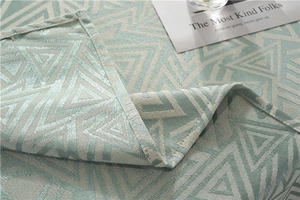 Detail of mint green and beige geometric jacquard weave tablecloth with triangle pattern