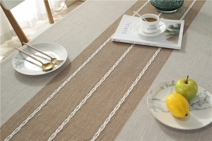 Detail of grey cotton linen table runner with brown stripes and woven texture