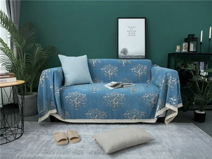 Detail of blue chenille sofa cover with floral prints and vintage lace trimmings