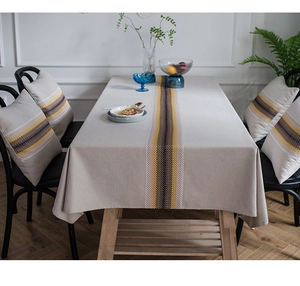 Detail of modern linen table runner with geometric stripes and matching cushion set