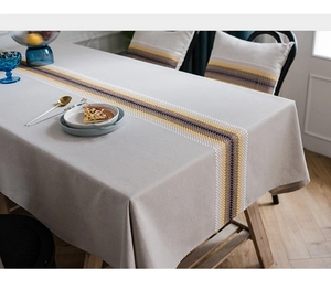 Detail of linen cotton table runner with modern yellow and black geometric embroidery