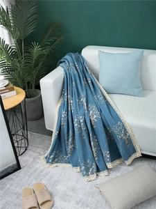 Detail of blue chenille sofa cover showing jacquard floral patterns and beige lace edges