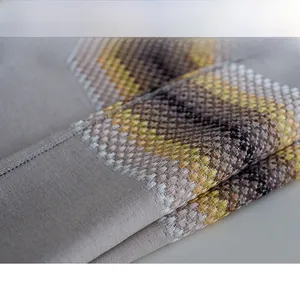 Macro detail of the woven linen cotton fabric showing high-density geometric embroidery texture