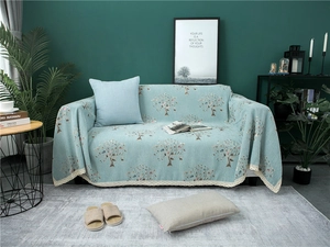 Detail of green chenille sofa cover with leaf patterns and elegant white lace edges