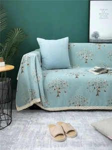Detail of mint green chenille sofa cover with floral pattern and white lace edging