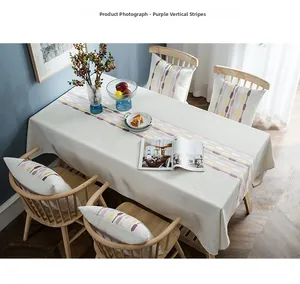 Detailed embroidery texture on linen-cotton table runner with purple vertical stripes