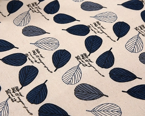 Close-up of leaf pattern and artistic typography on thick poly-cotton table cloth fabric