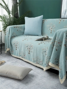 Detailed view of light blue chenille sofa cover with floral patterns and lace trim
