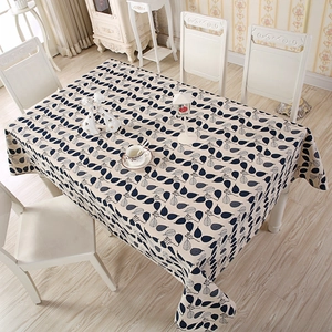 Detailed top view of a cream rectangular tablecloth with dark blue leaf patterns