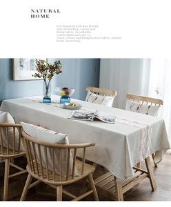 Detail of linen texture and colorful striped embroidery on a modern beige table runner