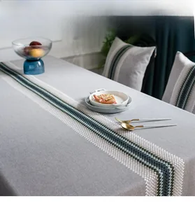 Close-up of modern textured linen table runner with woven geometric pattern and fringe
