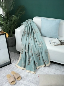 Close-up of chenille sofa cover showing vintage leaf patterns and beige crochet lace trim