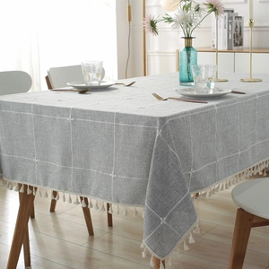 Rectangular light gray linen table cloth with floral embroidery and white tassels