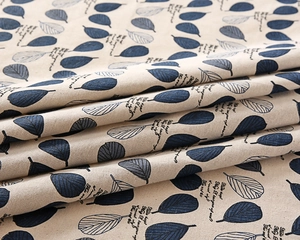 Detailed view of striped linen fabric with blue leaf prints and decorative text