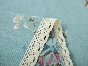 Detail of chenille fabric texture with elegant white lace trim and silver jacquard pattern