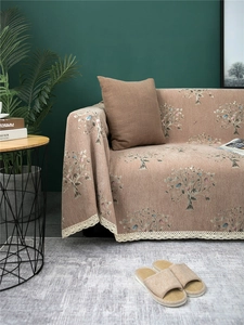 Detailed view of thick chenille sofa cover featuring tree patterns and white lace trim