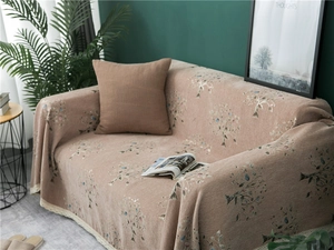 Close-up of thick chenille sofa cover with vintage leaf patterns and white lace trim