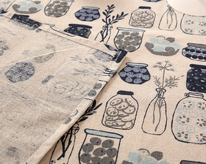 Detail of striped linen-cotton tablecloth showing fabric texture and neat hemmed edges