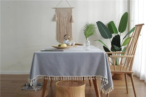 Detail of light blue tablecloth with white fringe tassels in a Nordic style setting