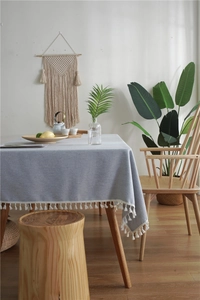 Close-up of Nordic grey tablecloth with white tassel edges and fine linen texture