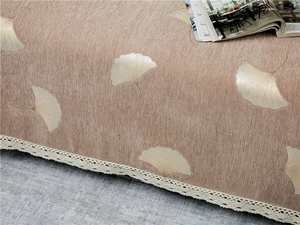 Detailed view of brown chenille sofa cover featuring ginkgo leaf embroidery and lace edge