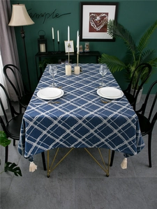Close-up of blue geometric jacquard tablecloth with thick texture and cream fringe tassels