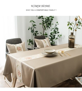 Close-up of geometric jacquard tablecloth and floral embroidered table runner in champagne
