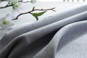 Detail of light blue textured linen tablecloth fabric with natural weave and soft folds