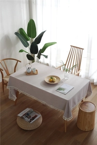 Macro detail of high-quality light grey linen tablecloth with white decorative tassels