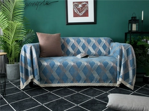 Detail of blue chenille sofa cover with silver diamond patterns and cream lace edges