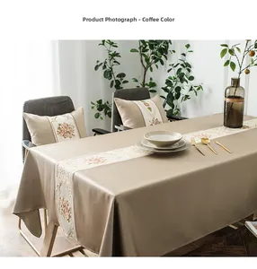 Detailed close-up of coffee-colored luxury table runner with floral embroidery and sateen finish
