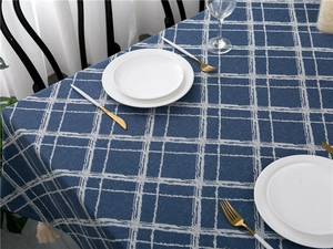 Detailed view of dark blue and beige checkered cotton linen tablecloth with tassel edges