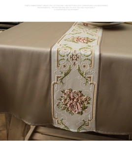 Close-up of floral embroidery on champagne satin-feel fabric table runner