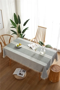 Detailed view of grey cotton linen table runner with white lace and tassel fringes