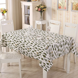 Close-up of Nordic style tablecloth featuring small green tree patterns on beige fabric
