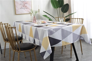 Detail of waterproof tablecloth with grey and yellow geometric triangles and deer motif