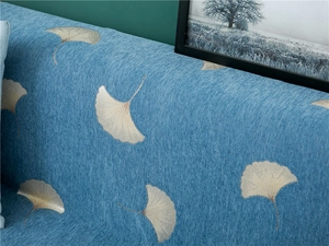 Detail of blue chenille sofa cover with thick texture and ginkgo leaf jacquard pattern