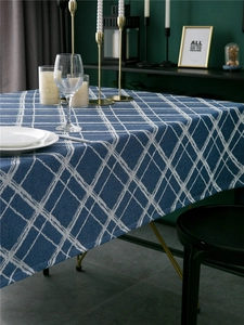 Detail of navy blue plaid tablecloth featuring modern jacquard texture and white rhombic patterns