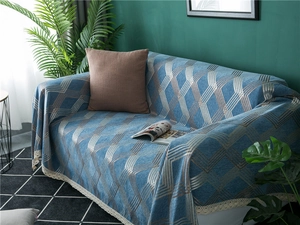 Detail of blue chenille sofa cover with golden geometric patterns and white lace edges