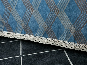 Detail of blue chenille sofa cover showing geometric patterns and white lace trim