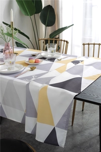 Detail of waterproof tablecloth with modern yellow and grey geometric triangle pattern
